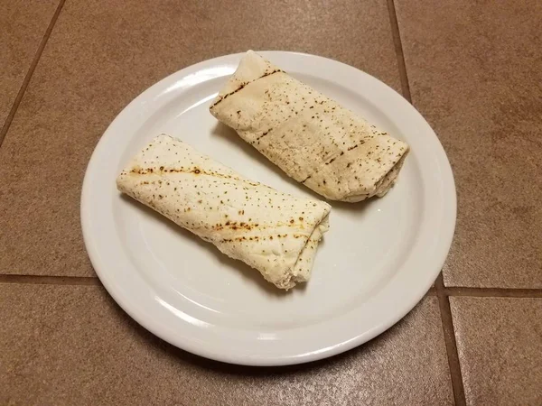 Deux Burritos Surgelés Sur Une Assiette Blanche Sur Sol Carrelé — Photo