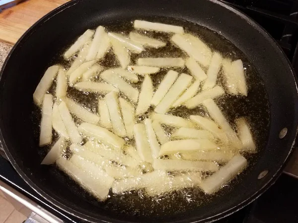 뜨거운 기름에 감자튀김 위에서 프라이팬에 튀기는 — 스톡 사진