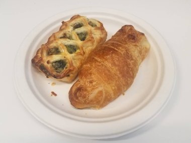 Bir ıspanak ve beyaz tabakta bir kruvasan daha.