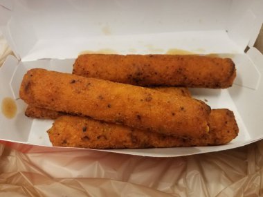 Baharatlı ve yağlı tavuklar yağ lekeleri ve plastik torbayla kutuda.