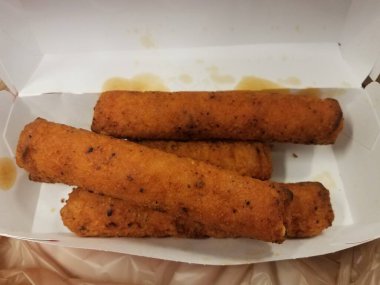 Baharatlı ve yağlı tavuklar yağ lekeleri ve plastik torbayla kutuda.