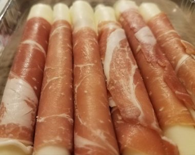 Etli dilimlere sarılmış mozarella peyniri çubukları.