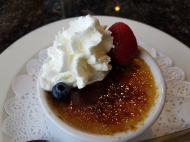 Krem şanti ve böğürtlenli kremalı Brulee tatlısı.