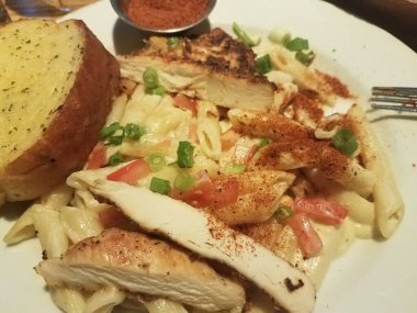 Baharatlı makarna, tavuk, ekmek ve baharatlı sos.