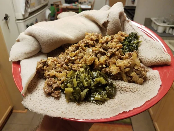 Etiopské Jídlo Hovězí Bryndáček Zelení Chlebem Červeném Talíři Kuchyni — Stock fotografie