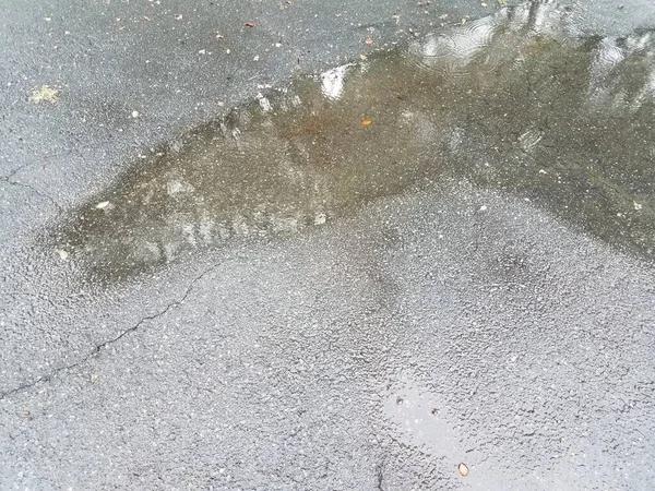 雨による大きな水溜りのあるアスファルトの車道 — ストック写真