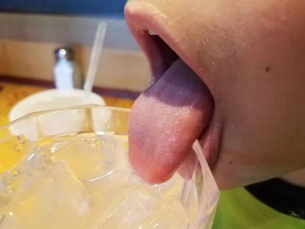 child mouth drinking cold water with ice cubes out of glass