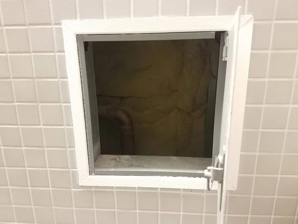 Viele Quadratische Graue Fliesen Einer Badezimmerwand Und Einer Kleinen Tür — Stockfoto