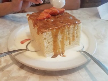 Porto Riko 'dan üç büyük boy sütlü ya da kremalı kek, kaşıklı ve çilekli.