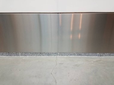 Gümüş duvarlı gri ya da beyaz beton zeminde uzun çatlaklar