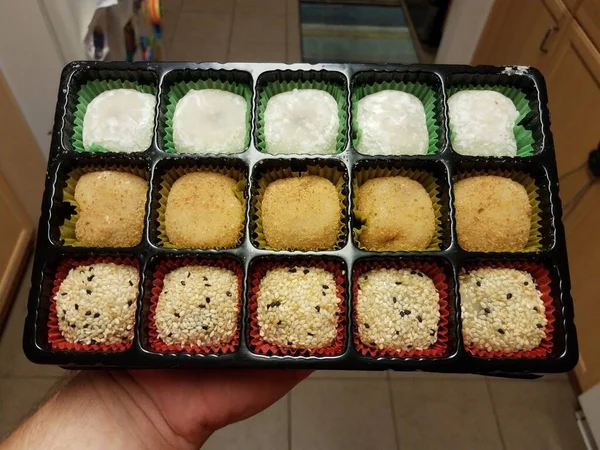 手在厨房里拿着五颜六色的日本莫奇小吃或甜点 — 图库照片