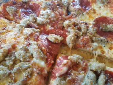 Yağlı sosis, pepperoni ve peynirli pizzayı yakın.