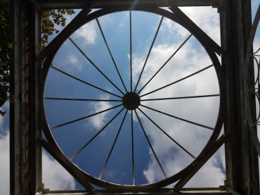 Dairesel metal yapı ve bulutlu mavi gökyüzü