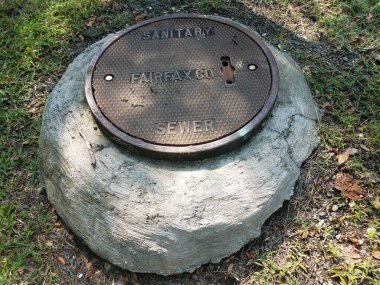 Dairesel metal lağım çukuru ve gri çimento.