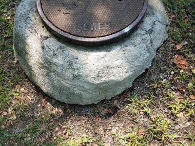 Dairesel metal lağım çukuru ve gri çimento.