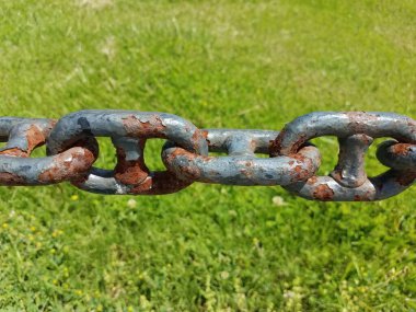 Paslı metal zincir yakın çekim ve yeşil çimen