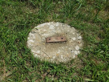 Yeşil çimenlerde paslı metal parçalarıyla beton dairesi