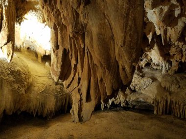Mağarada veya mağarada kahverengi sarkıtlar ve dikitler
