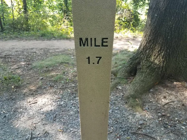 a grey cement mile 1.7 marker along a trail