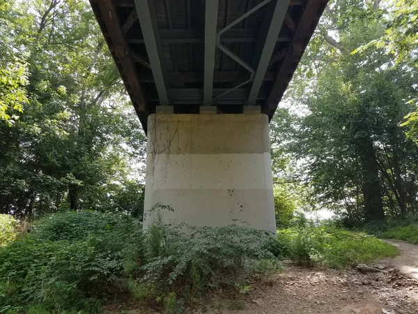 cement support column underneath a wooden covered bridge