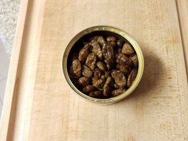 Tahta üzerinde metal böcek, böcek ya da larva konservesi