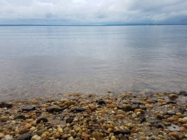 Sakin su ve taşlar ya da kumsalda ya da kıyıda kayalar