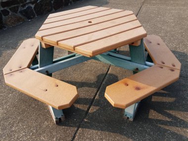 Çimento ya da kaldırımda kahverengi ahşap altıgen piknik masası