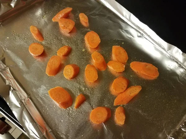 烤盘或盘子中金属箔上的橙色胡萝卜片 — 图库照片