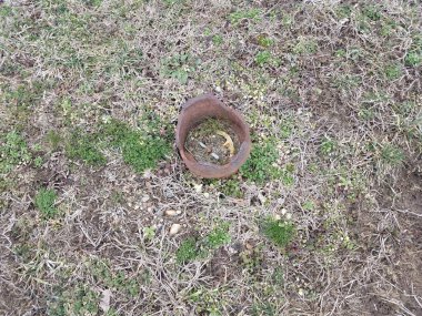 Kırık paslı metal çıkış borusu yeşil ve kahverengi çimlerde temiz boru