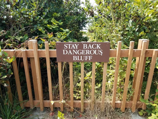 Brown Stay Back Dangerous Bluff Sign Wood Fence Green Plants — Stock Photo, Image