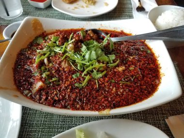 Kırmızı biber ve kırmızı yağ ile doldurulmuş büyük bir kase baharatlı Çin bifteği.