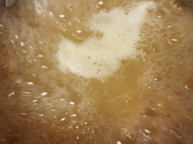 Kabarcıklı ve yağlı bir tencerede kaynar su.