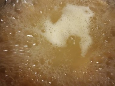 Kabarcıklı ve yağlı bir tencerede kaynar su.