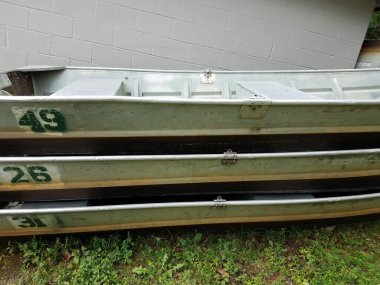 Beyaz çimento binasının yanına yığılmış sayıları olan birkaç metal tekne.