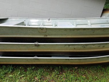 Beyaz çimento binasının yanına yığılmış birkaç metal tekne.