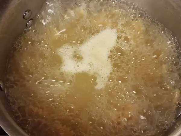 把开水放在有气泡和油的锅里 — 图库照片