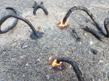 Kara asfaltta bir sürü kömür yılanı havai fişeği var.