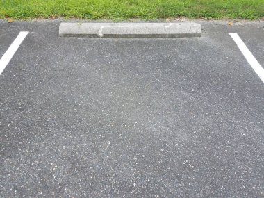 Beyaz çizgileri ve gri çimento kaldırımı olan siyah asfalt