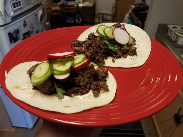 Handen Håller Nötkött Tacos Och Gurka Och Rädisa Röd Tallrik — Stockfoto