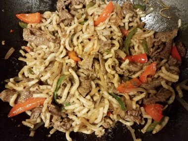 sığır eti ve erişte ve yeşil ve kırmızı biber kızartma tavasında veya tavada