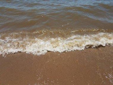 Dalgalar ve kayalarla ıslak ve kuru kum