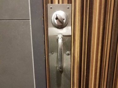 Ahşap banyo ya da tuvalet kapısı ve kırık metal kilidi var.