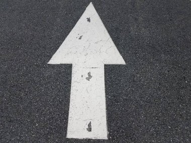 Siyah asfalt üzerinde yukarı ya da ileri gösteren beyaz ok