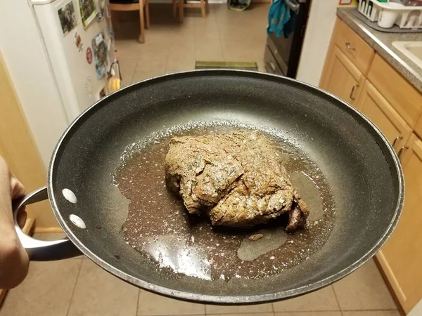 Mão Segurando Frigideira Com Carne Bovina Sucos Cozinha — Fotografia de Stock