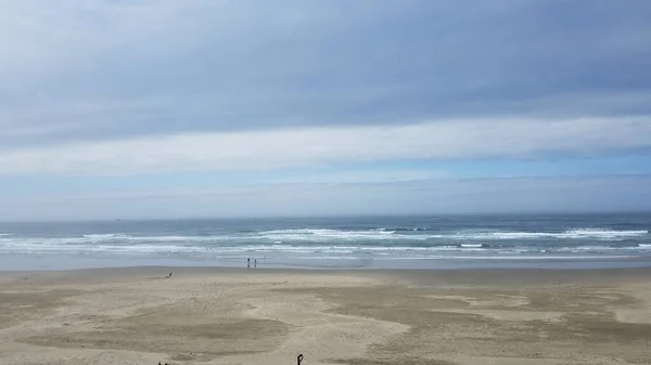 乾燥した湿った砂と水と波と雲を持つビーチ — ストック写真