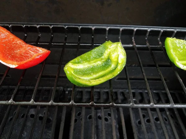 Pimentas verdes e vermelhas cozinhando em churrasqueira — Fotografia de Stock