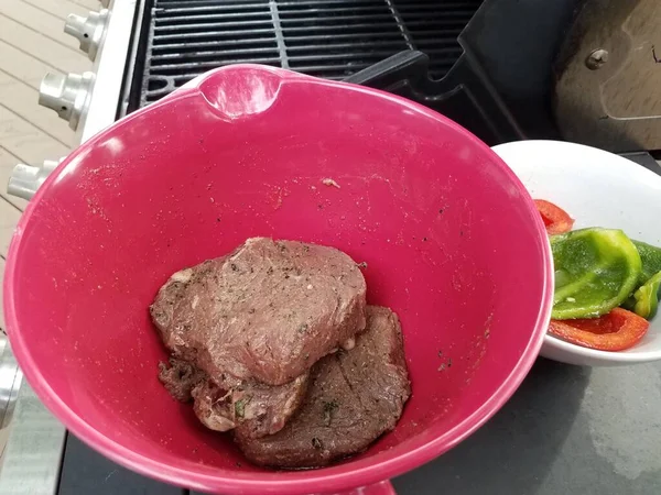 Ochucené steaky v červené nádobě s paprikou a grilem — Stock fotografie