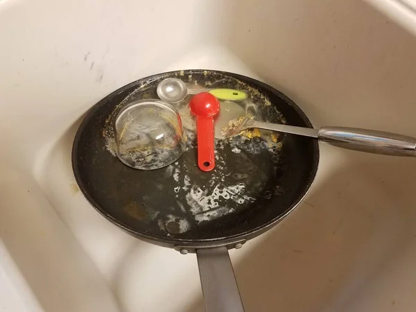 Sucia sartén grasosa con agua en el fregadero de la cocina — Foto de Stock