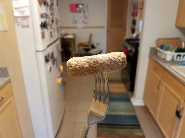 Frosset pølsekød på en gaffel i køkkenet - Stock-foto