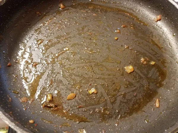 油炸锅或锅中的洋葱和油液体 — 图库照片